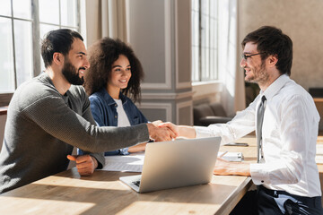 Couple handshake mortgage officer worker, accept bank loan terms and rates feel satisfied. Make financial deal, take credit, buying insurance cover, receive professional consult, sign contract concept